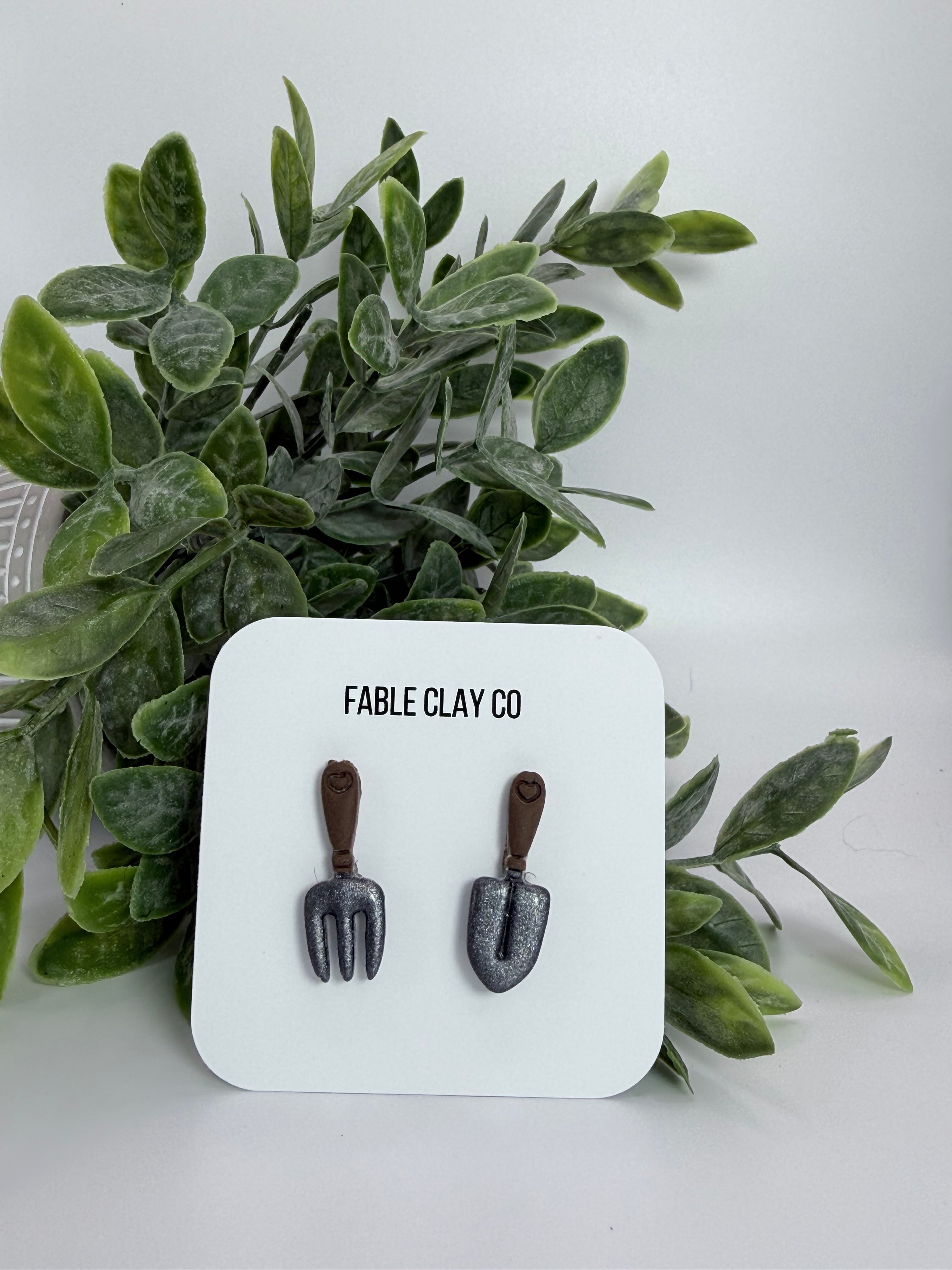 Set of garden tools from Fable Clay Co, including trowel and hand rake, ideal for gardening and planting activities.