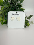 Fresh garlic bulbs from Fable Clay Co displayed on a neutral surface, showcasing their textured outer skins.