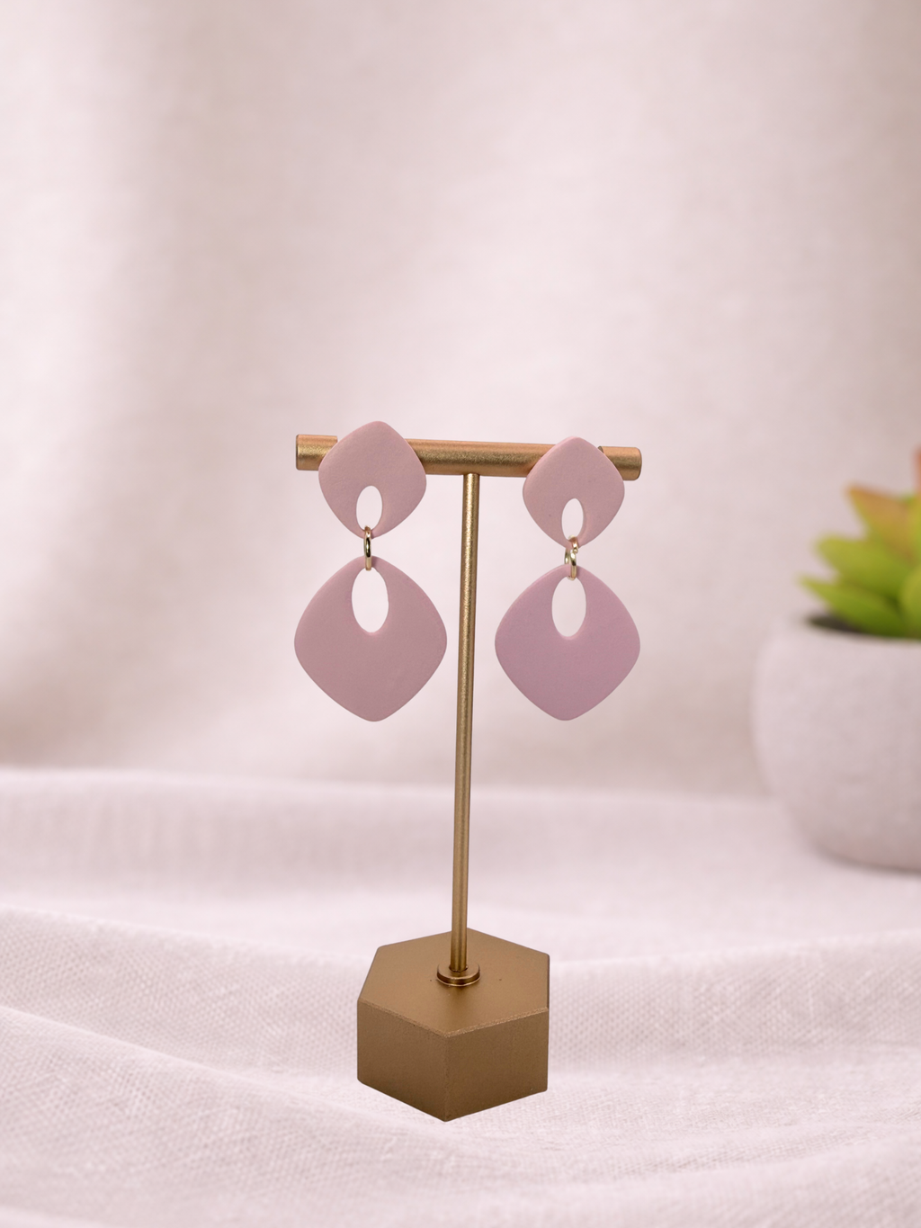 Fable Clay Co's ISLA soft drop statement earrings featuring colorful, handcrafted clay designs hanging from gold hooks.