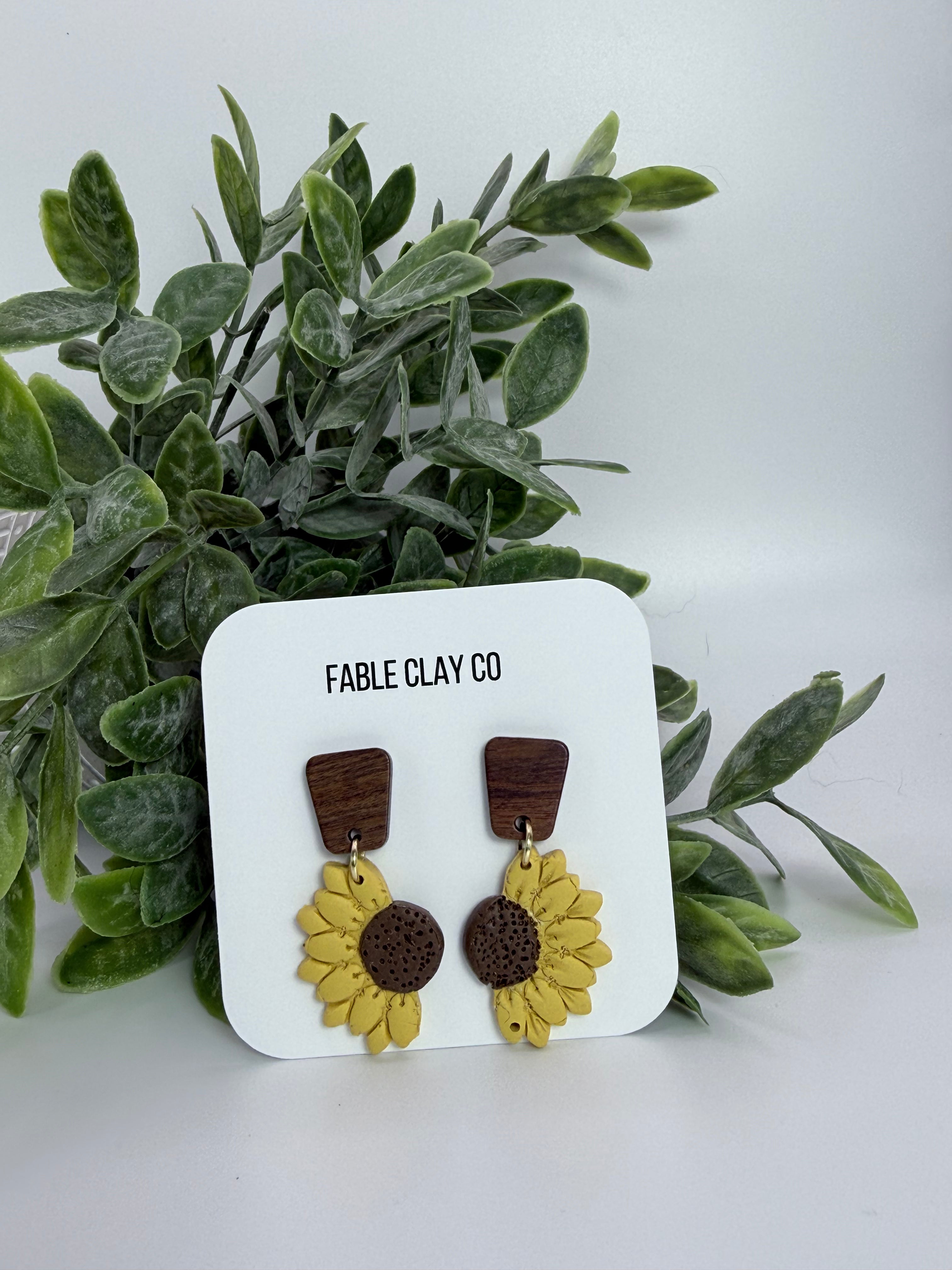 Fable Clay Co sunflower half bloom ceramic sculpture with detailed yellow petals and green stem on neutral background.